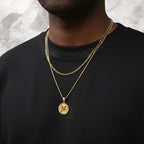 Championofgod Mother of God quarter necklace with gold chain layered over a black crewneck shirt.